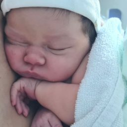 Recién nacida Bebé recién nacido durmiendo con una manta blanca y una gorra ligera.